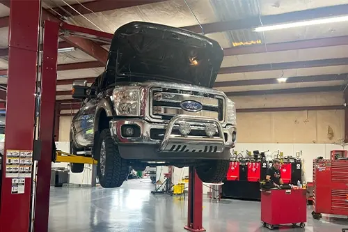 Suspended Ford pick-up truck at RDI Power's. Concept image of “Truck Transmission Talk: Examining the Ford E40D and 4R100” | RDI Power in Brooksville, FL.