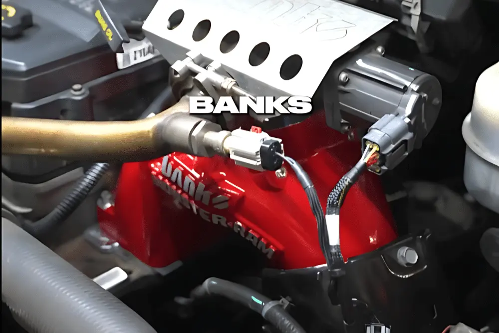 diesel performance parts, diesel repair in Brooksville, FL at RDI Power. Performance intake manifold by Banks installed on a diesel engine. The image highlights a red Banks Monster-Ram intake system with connected sensors and wiring, designed to improve airflow and engine performance in turbocharged diesel trucks.