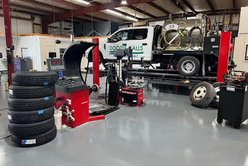 Fleet tire maintenance and services for trucks in Brooksville, FL with RDI Power. Image of local fleet truck on shop alignment machine for fleet tire services with new and old truck tires around as well as tire balancing machine.