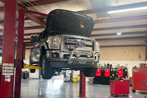 Suspended Ford pick-up truck at RDI Power’s. Concept image of “Truck Transmission Talk: Examining the Ford E40D and 4R100” | RDI Power in Brooksville, FL.